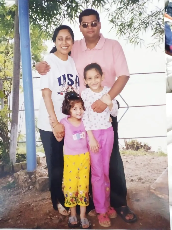 A family of four outdoors, the two children in front